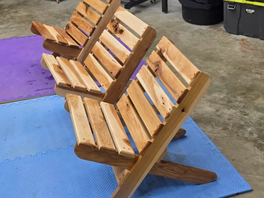 Three handcrafted wooden outdoor chairs in the workshop